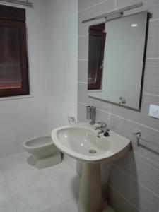 łazienka z umywalką, toaletą i lustrem w obiekcie Apartamento A Nave w mieście Fisterra