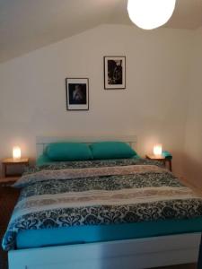 a bedroom with a blue bed with two pictures on the wall at Cherry flower ( Trešnjin Cvet ) apartment in Višegrad