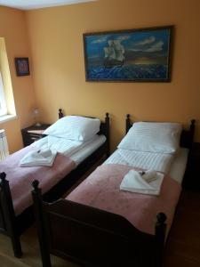 duas camas sentadas uma ao lado da outra num quarto em Midi em Poznań