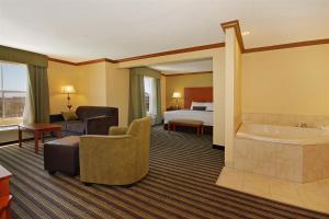 Habitación de hotel con cama y bañera en Best Western Plus Seawall Inn & Suites by the Beach, en Galveston