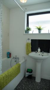 ein Badezimmer mit einem Waschbecken, einer Badewanne und einem Waschbecken in der Unterkunft Danny’s Place in Derry Londonderry