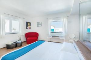 a bedroom with a bed and a red chair at Beauty Beach Villa in Monopoli