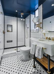 ein Badezimmer mit einer Badewanne, einem WC und einem Waschbecken in der Unterkunft Merrion Row Hotel and Public House in New York