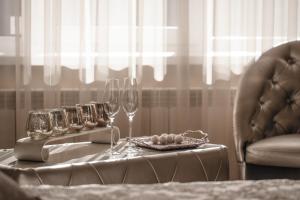 a table with a tray of wine glasses and a plate of food at Jacuzzi Apartamentai Relaks in Klaipėda