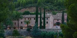 a large house with a person walking in front of it at Terra Dominicata - Hotel & Winery - Adults Only in Escaladei