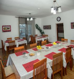 a dining room with a table with red and white tablecloths at Sweet House GH in Karakol