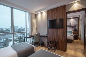 a hotel room with two beds and a flat screen tv at Puerto Norte Design Hotel in Rosario