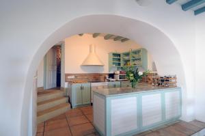 un arco en una cocina con armarios verdes y una escalera en Sfendoni House, en Frilingiánika