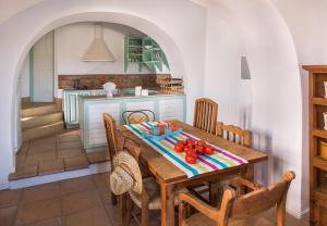 uma cozinha com uma mesa de madeira e cadeiras em Sfendoni House em Frilingiánika