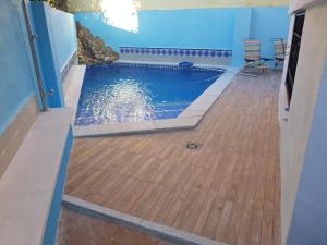 a swimming pool with a wooden floor and blue walls at VILLA HISPANO-BRASILEÑA-Fiestas NO in Purchil
