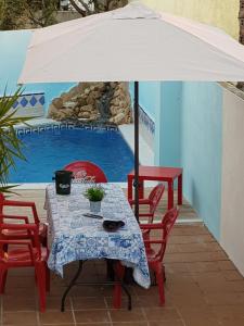 a table with an umbrella in front of a pool at VILLA HISPANO-BRASILEÑA-Fiestas NO in Purchil