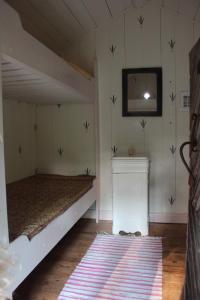 OckelboにあるBo primitivt i härbret på Oklagårdのベッドルーム1室(ベッド1台、壁掛け鏡付)