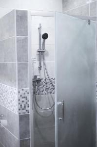 y baño con ducha y puerta de cristal. en Victory Apartment, en Zhensna Polʼska