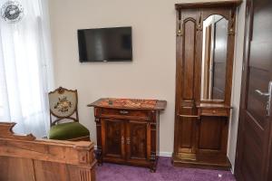 a room with a tv and a table and a chair at Willa Sorrento in Szczecin