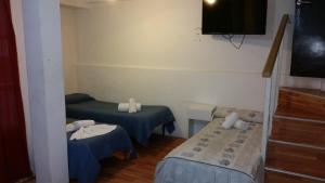 a room with two beds and a flat screen tv at Hotel Dallas Center in Mar del Plata