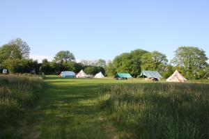 un grupo de tiendas de campaña en un campo con hierba en The Valley Bell Tents, Bring Your Own Bedding, en Amroth