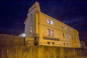 a yellow building on top of a wall at night at Hospedagem Casa das Regadas in Vale de Cambra