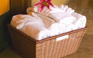 a basket of towels with a flower on top of it at Pacific Terrace Hotel in San Diego