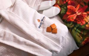 a white towel with a cookie on top of it at Pacific Terrace Hotel in San Diego