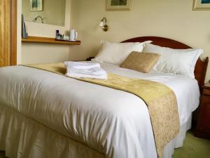 ポートリーにあるWoodlandsのベッドルーム(白い大型ベッド、白い枕付)