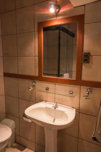uma casa de banho com um lavatório, um espelho e um WC. em La Escondida Hostal em Sucre