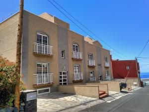 a brown building with white balconies on a street at Apartamentos Isora in Frontera