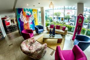 sala de estar con sillas rosas y azules y reloj en Embassy Quito en Quito