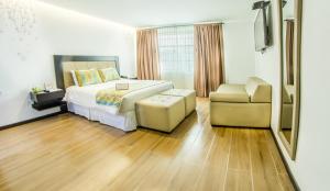 1 dormitorio con 1 cama, 1 sofá y 1 silla en Embassy Quito, en Quito
