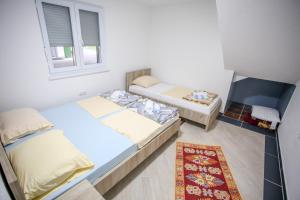 1 dormitorio con 2 camas y alfombra en Apartments River Una 3, en Bihać