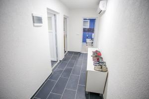 a hallway with a row of shoes sitting on a bench at Apartments River Una 3 in Bihać +6 photos