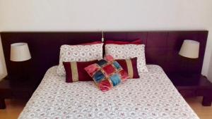 Bett mit vier Kissen und zwei Lampen in der Unterkunft Apart. Dunas da Torreira in Torreira