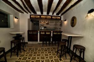 un bar con mesas y taburetes en una habitación en Casa Las Tinajas en Iznájar