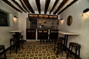 a bar with tables and stools in a room at Casa Las Tinajas in Iznájar