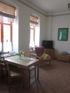 a living room with a table and chairs and a television at Ferienwohnung Pusteblume in Steinhöfel