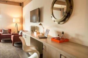a room with a desk with a laptop and a mirror at Harbor House Hotel and Marina in Galveston
