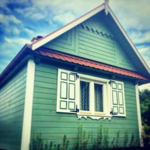 a green house with a window on the side of it at Agroturystyka w zielonym spichlerzu, Puszcza Białowieska in Czechy