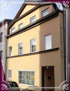 żółty budynek z drzwiami przed nim w obiekcie Pension Harmonie w mieście Erfurt