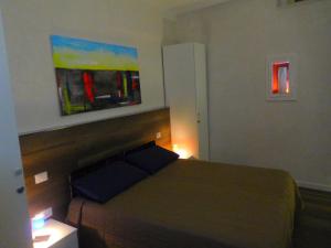a bedroom with a bed and a painting on the wall at Il Paradiso a Claustro Inferno in Altamura