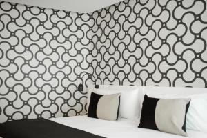 a bedroom with a black and white patterned wall at CasaSur Palermo Hotel in Buenos Aires