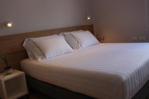 a bedroom with a large bed with white sheets and pillows at Tirana Terrace Apartments, near the Lake Park in Tirana
