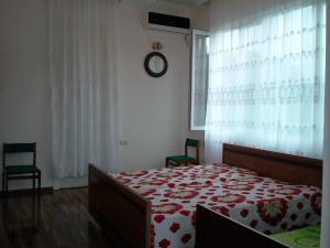 una camera da letto con un letto e un orologio a parete di liziko's House a Kobuleti