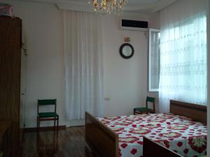una camera con un letto, due sedie e un orologio di liziko's House a Kobuleti