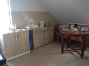 a small kitchen with a table and a sink at Agroturystyka 'Pod dębem' in Giżycko