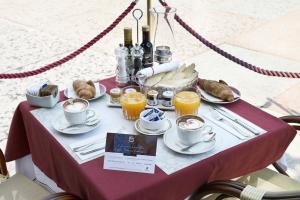 a table with cups and plates of food and drinks at Fratta5 Luxury Apartment in Verona