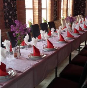 a long table with red napkins and red hats on it at Guesthouse Vanilla in Sjenica