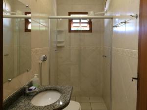 een badkamer met een wastafel en een douche bij Pousada Flores do Cerrado in Pirenópolis