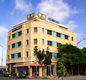 um edifício amarelo com placas em cima em Hotel Med Centro - Marcari em Barranquilla