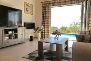 
a living room filled with furniture and a tv at ARILLAS HILLSIDE VILLA 3 - Provence in Arillas
