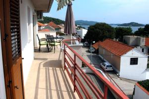 a balcony with a table and chairs and an umbrella at Apartmani TEO in Tisno