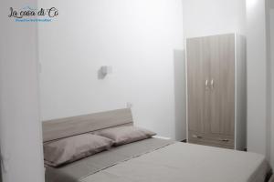 1 dormitorio blanco con 1 cama y armario en B&B La casa di Cò, en Nápoles